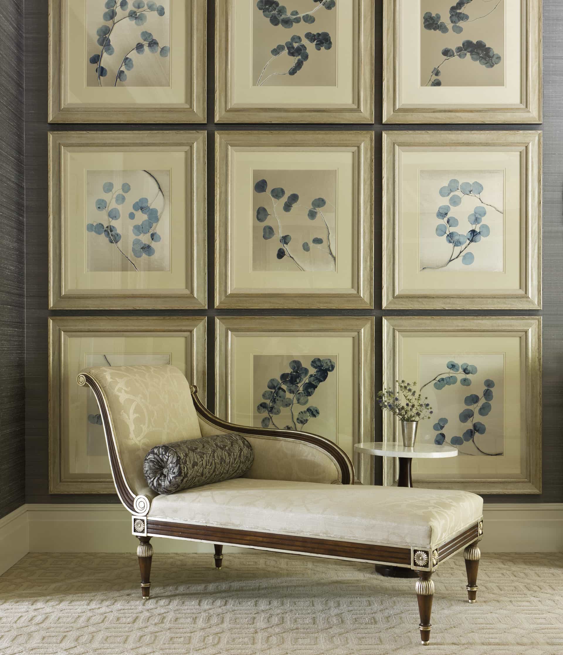 Grid of botanical paintings on the wall behind a chaise